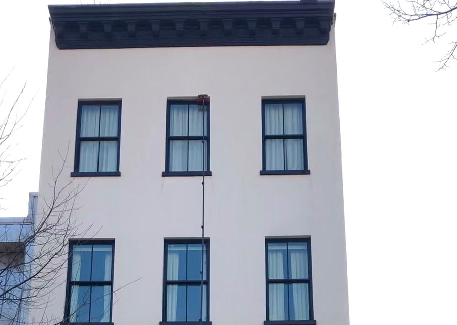 Water-fed pole reaching exterior windows on a Brooklyn building