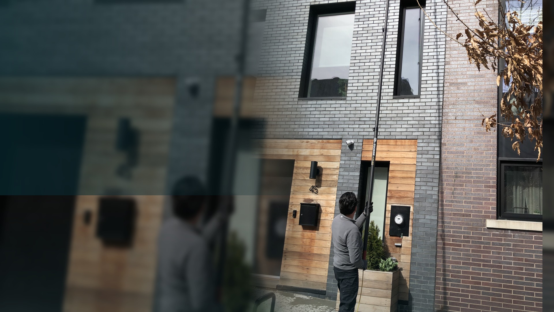 OctoPlus owner cleaning windows on a Brooklyn building with an extension pole